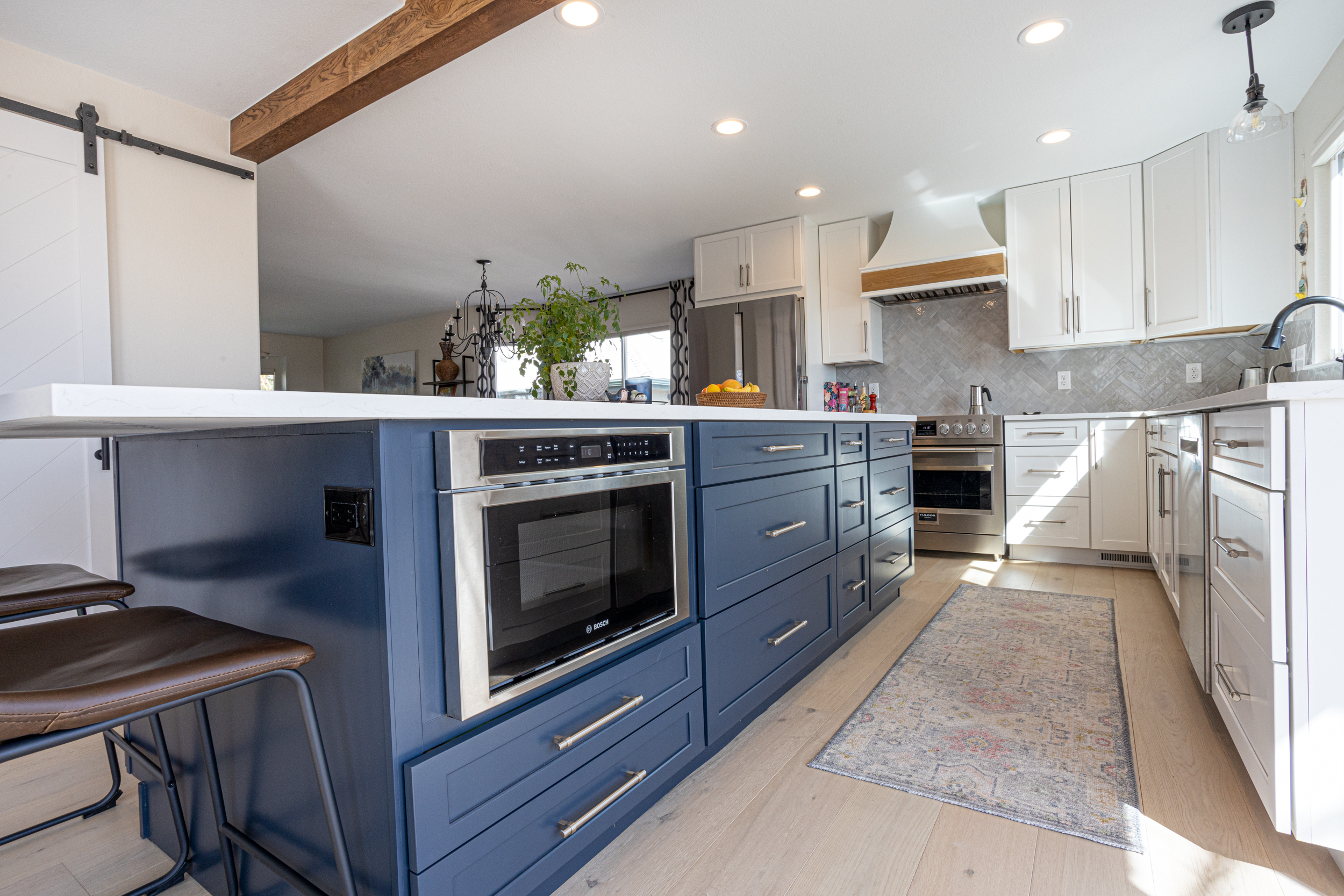 Kitchen bar with navy cabinets and beige stools